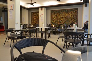 A restaurant with wicker chairs, tables, and a large decorative mural on the wall. - Sharaya Residence Patong (Patong)