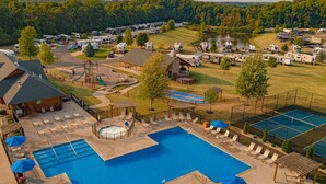A campground with RVs, a swimming pool, and a tennis court. - Sun Retreats Gun Lake (Hopkins)