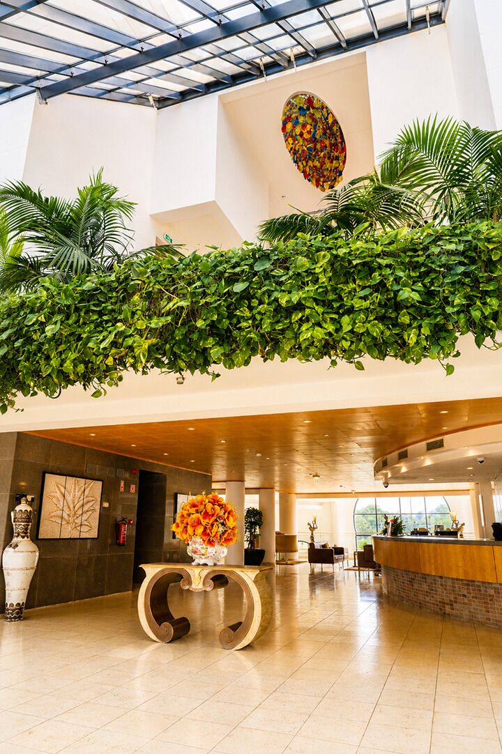 A spacious lobby with a high ceiling, a reception desk, and a large window.