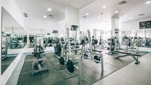 Un gimnasio con diversos equipos de ejercicio, espejos y un diseño moderno y limpio.