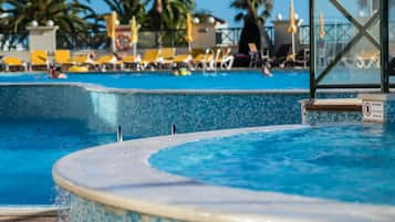 Piscine couverte, piscine extérieure, parasols de plage, chaises longues