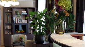 Un salon moderne avec une cheminée, un canapé, une table basse et diverses plantes.
