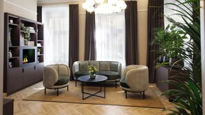 Un salon moderne comprenant un canapé, deux fauteuils, une table basse et une cheminée.