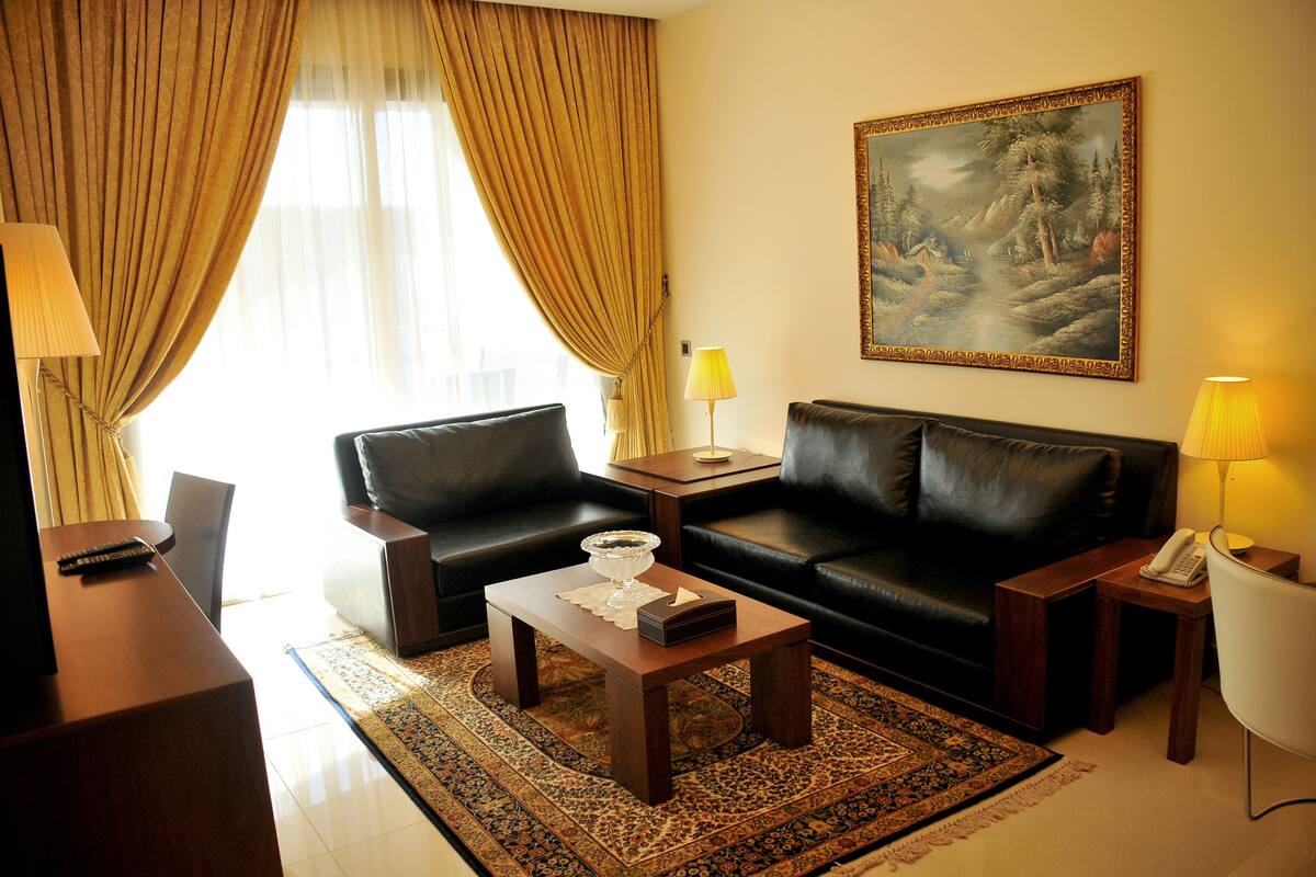 A living room with a sofa, a coffee table, a lamp, and a painting on the wall.