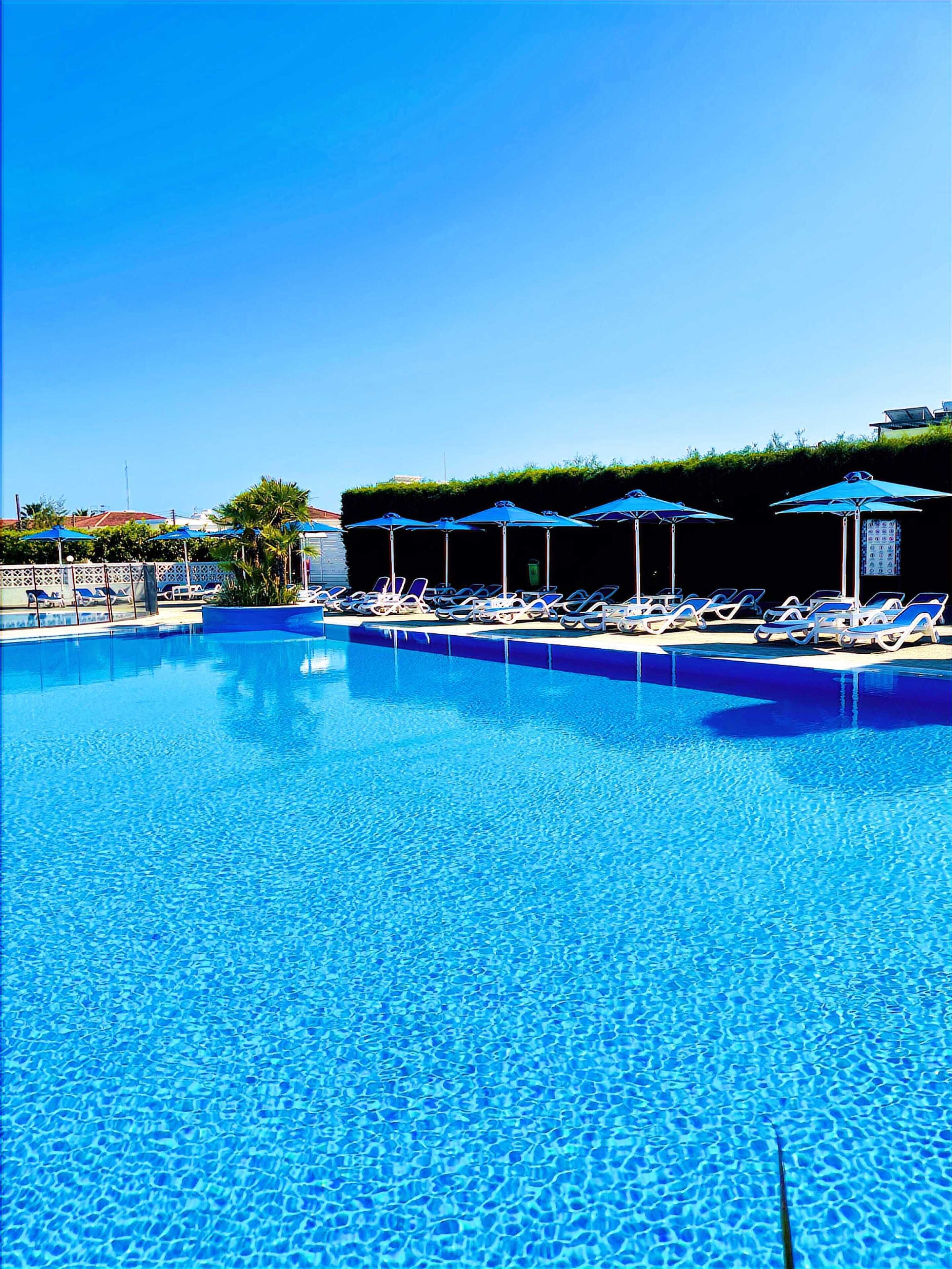 Piscine extérieure, parasols de plage, chaises longues