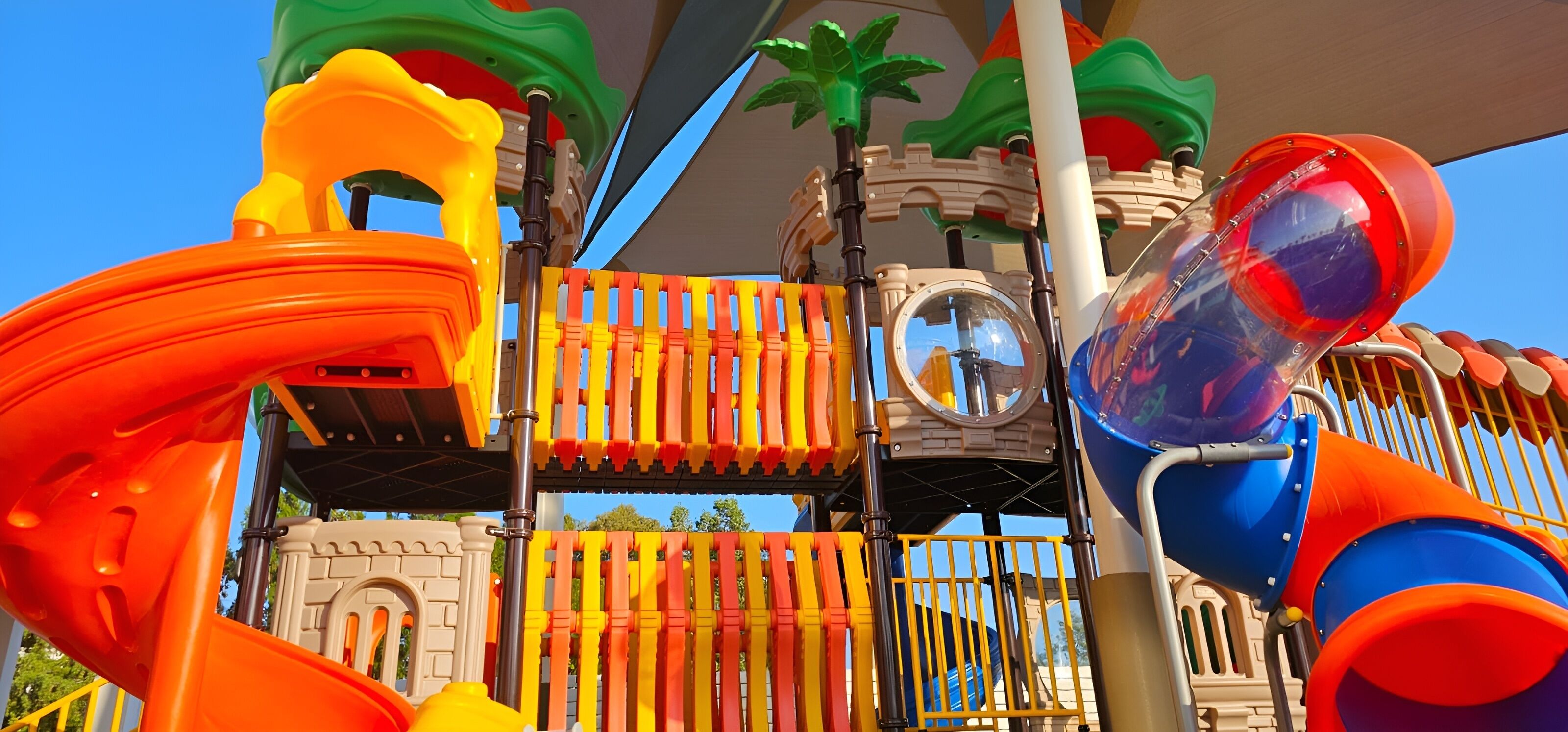 Une aire de jeux dotée de diverses installations, notamment des toboggans et des structures d’escalade.