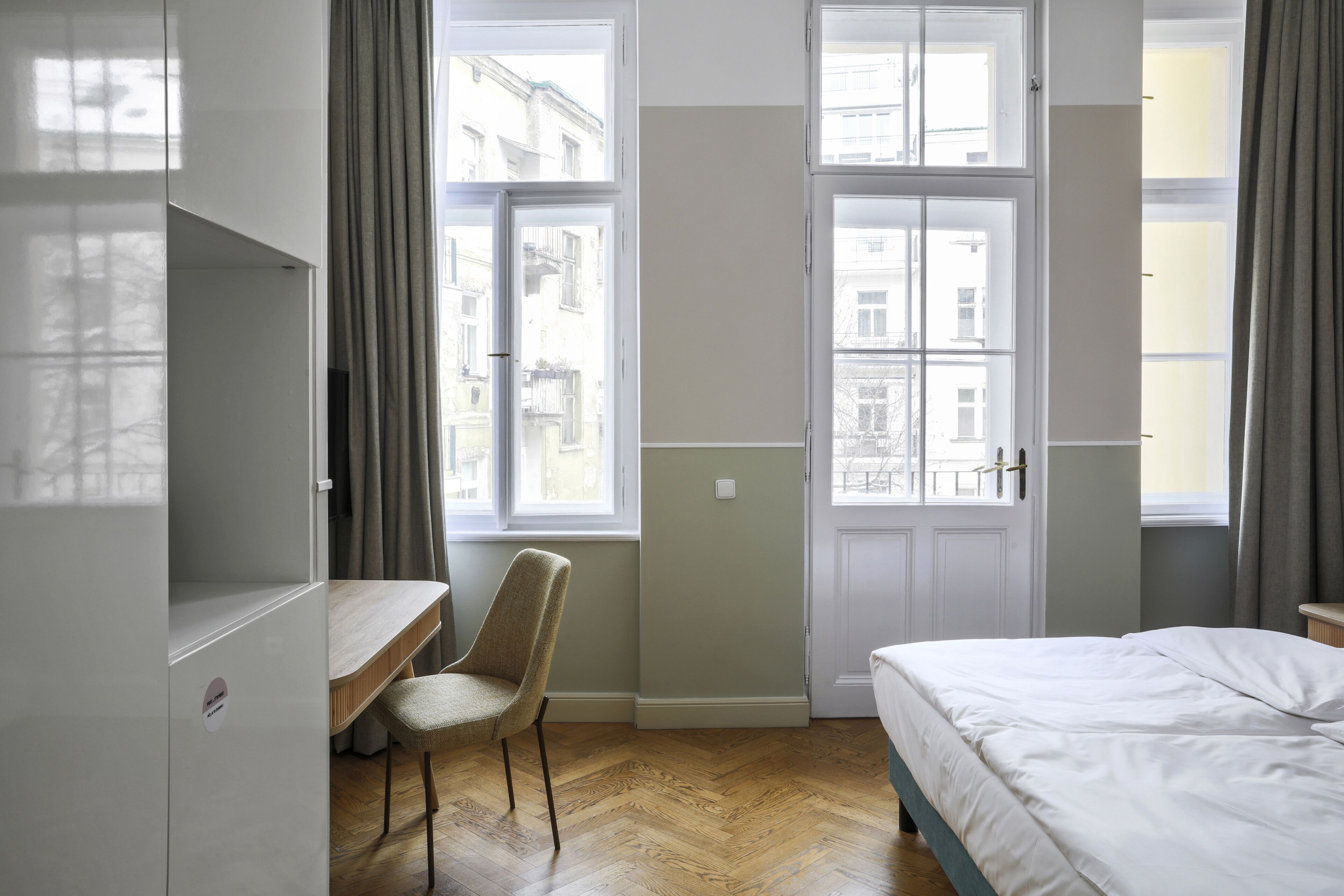 A bedroom with a bed, a desk, and a chair.
