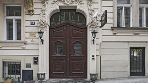 En historisk bygning med detaljeret arkitektur, en dobbelt trædør og en skilt med adresseangivelse.