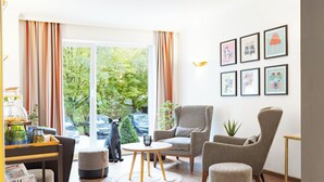 Una sala de estar moderna con un ventanal grande, un sofá, una mesa de centro y un gato.
