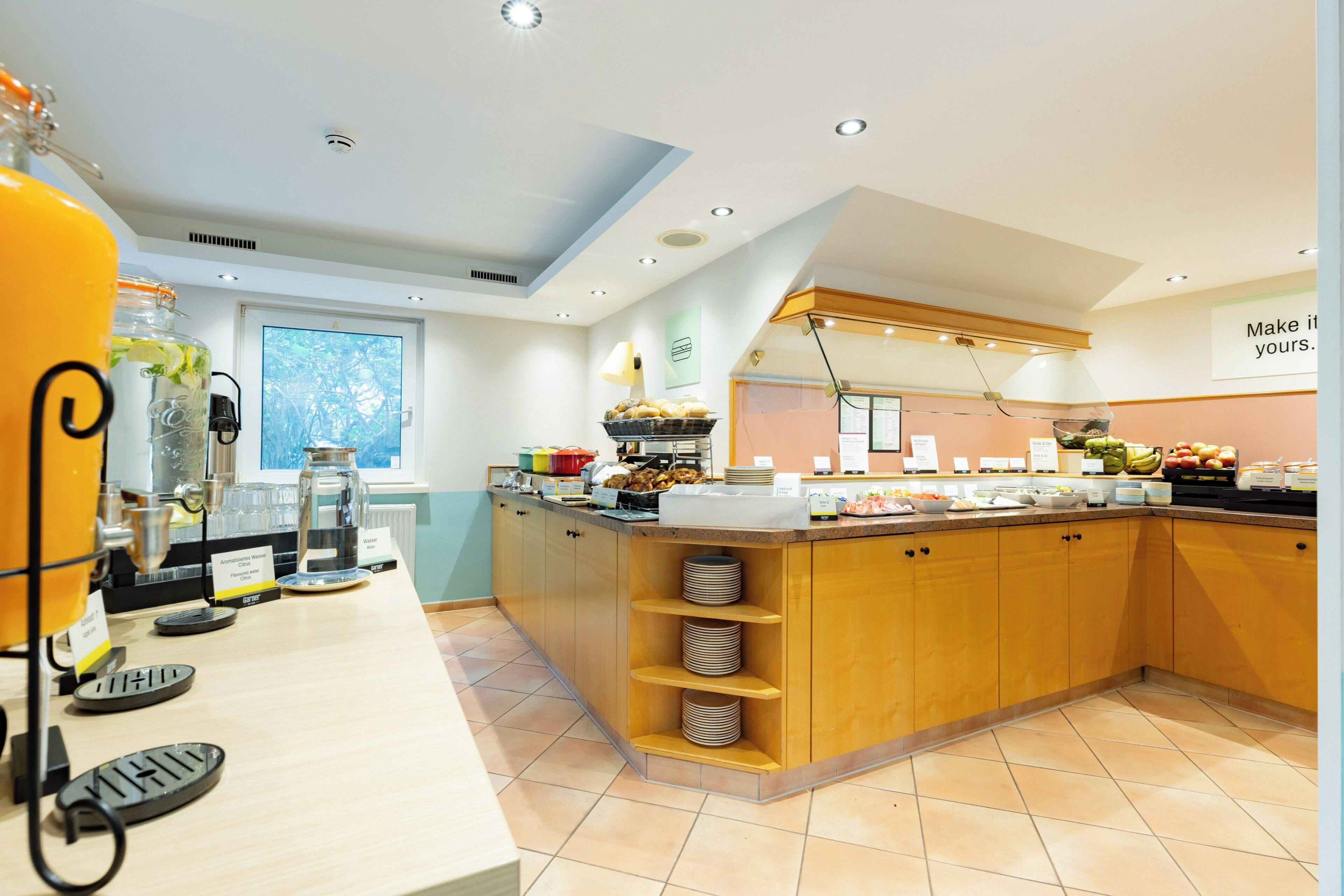 Una cocina moderna con una isla central, estanterías empotradas y diversos alimentos a la vista.