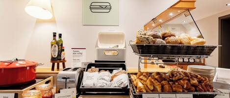 A breakfast buffet with various food items and a coffee station.