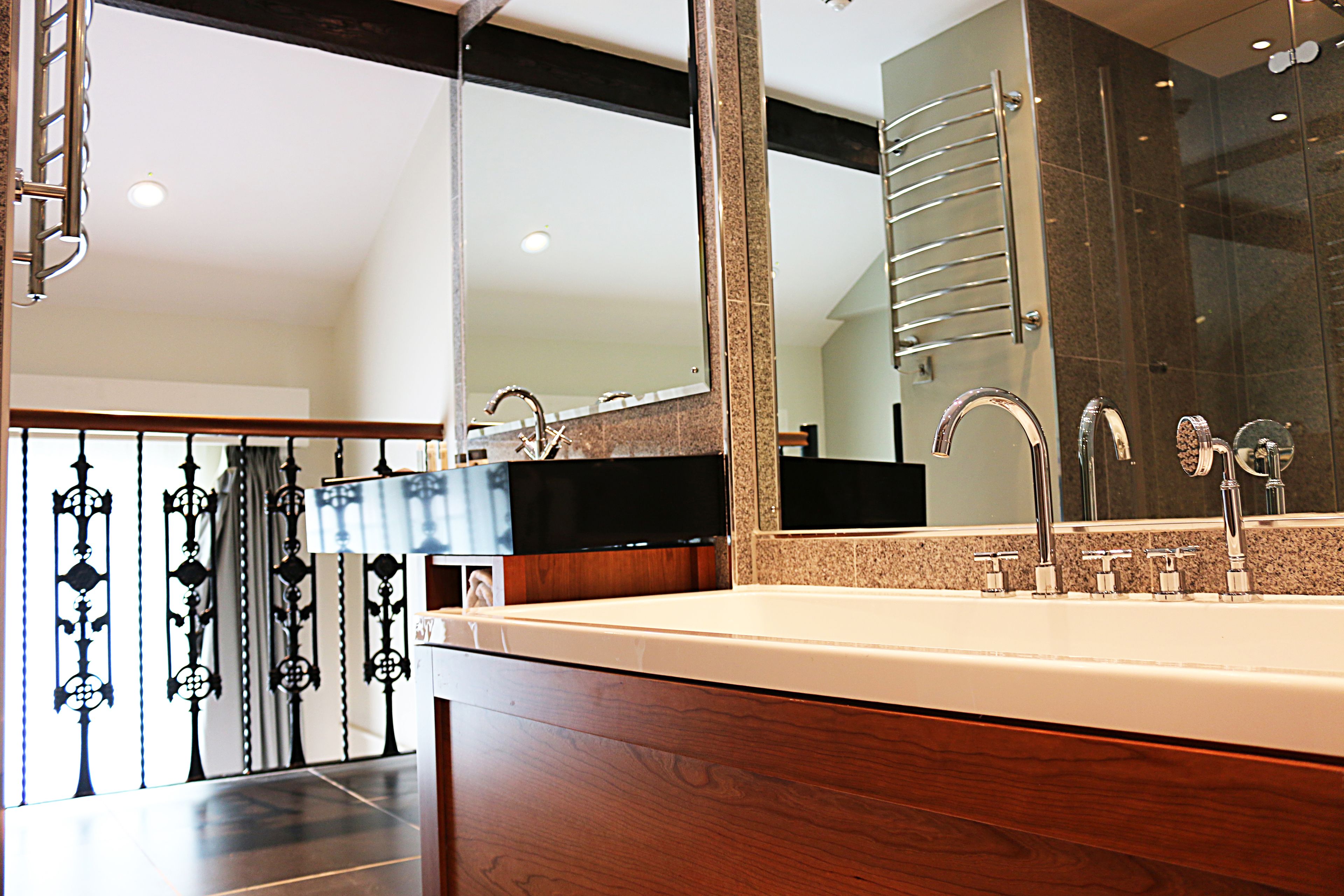 Un baño moderno con un espejo grande, un lavabo doble y una zona de ducha.
