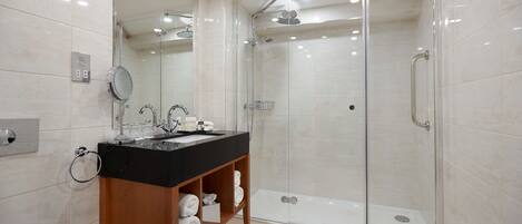 A modern bathroom with a glass-enclosed shower, a black sink vanity, and a mirror.