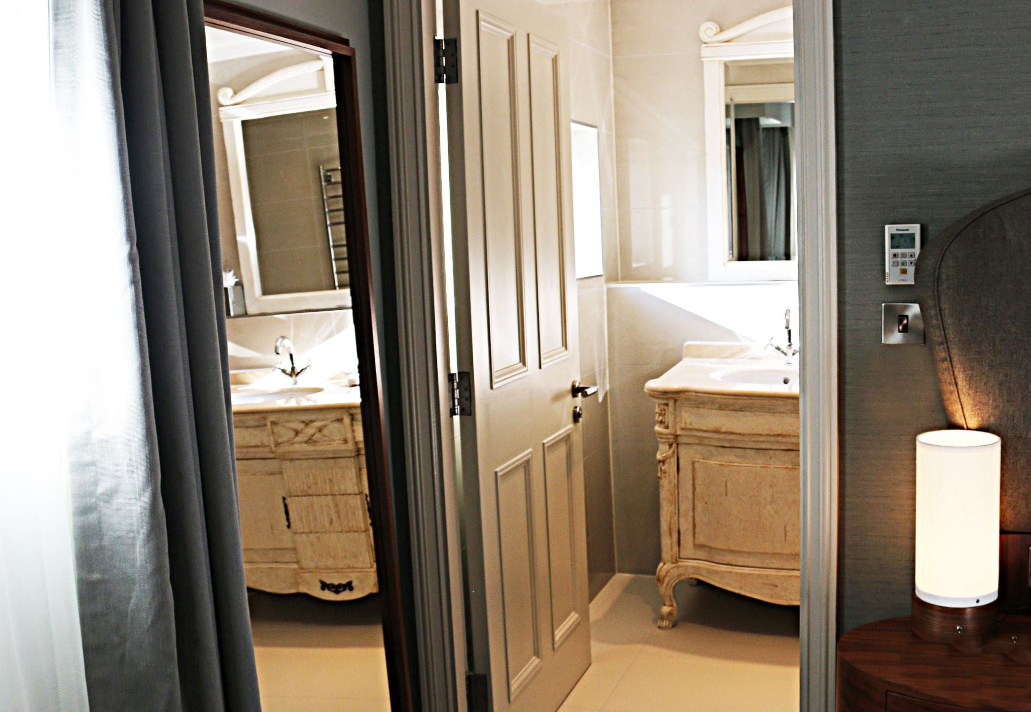 A bathroom with two sinks, a mirror, and a door.