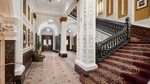 A grand lobby with a marble floor, ornate columns, a grand staircase, and a chandelier. - DoubleTree By Hilton Hotel & Spa Liverpool (Liverpool)