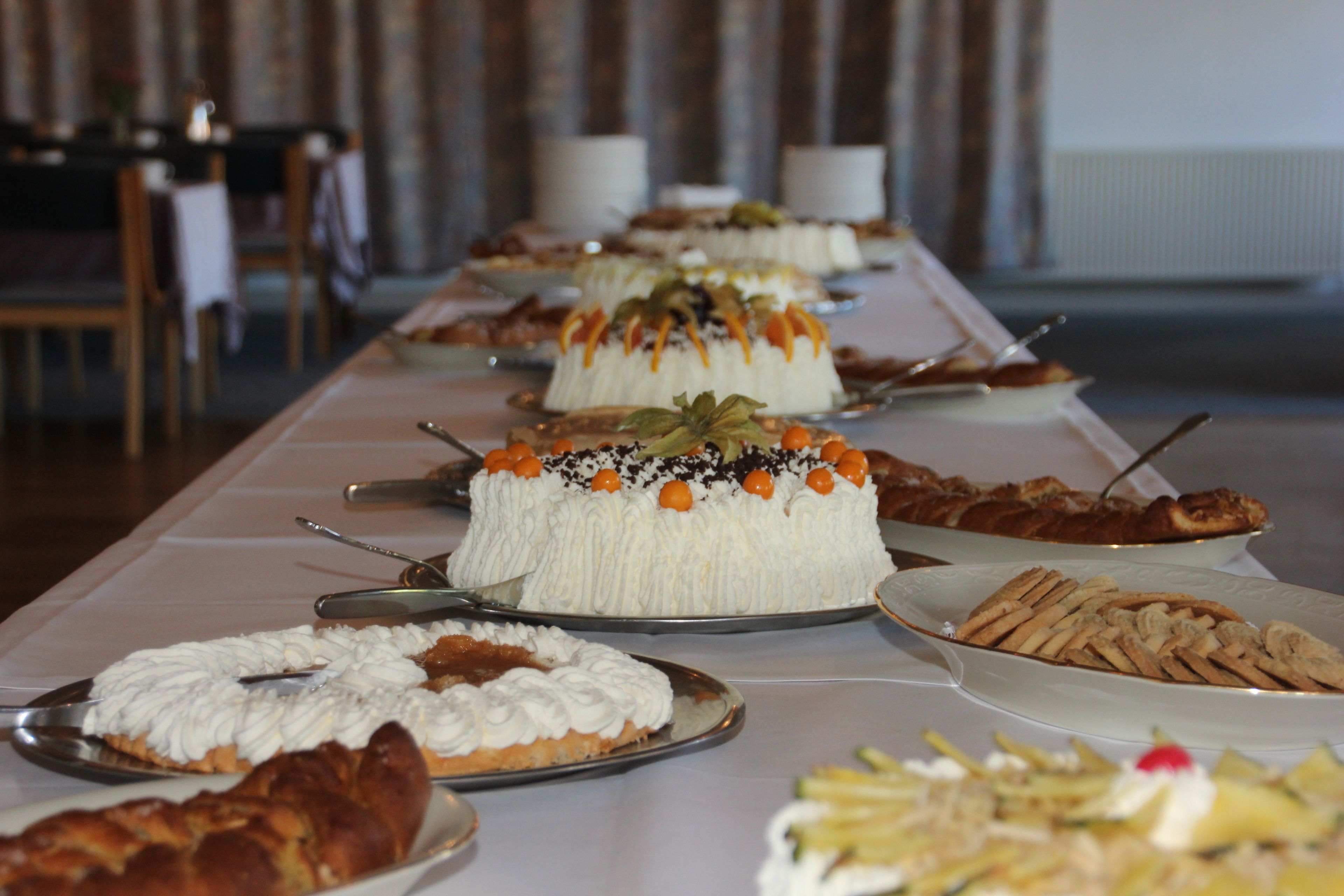 A buffet table with various desserts and pastries.
