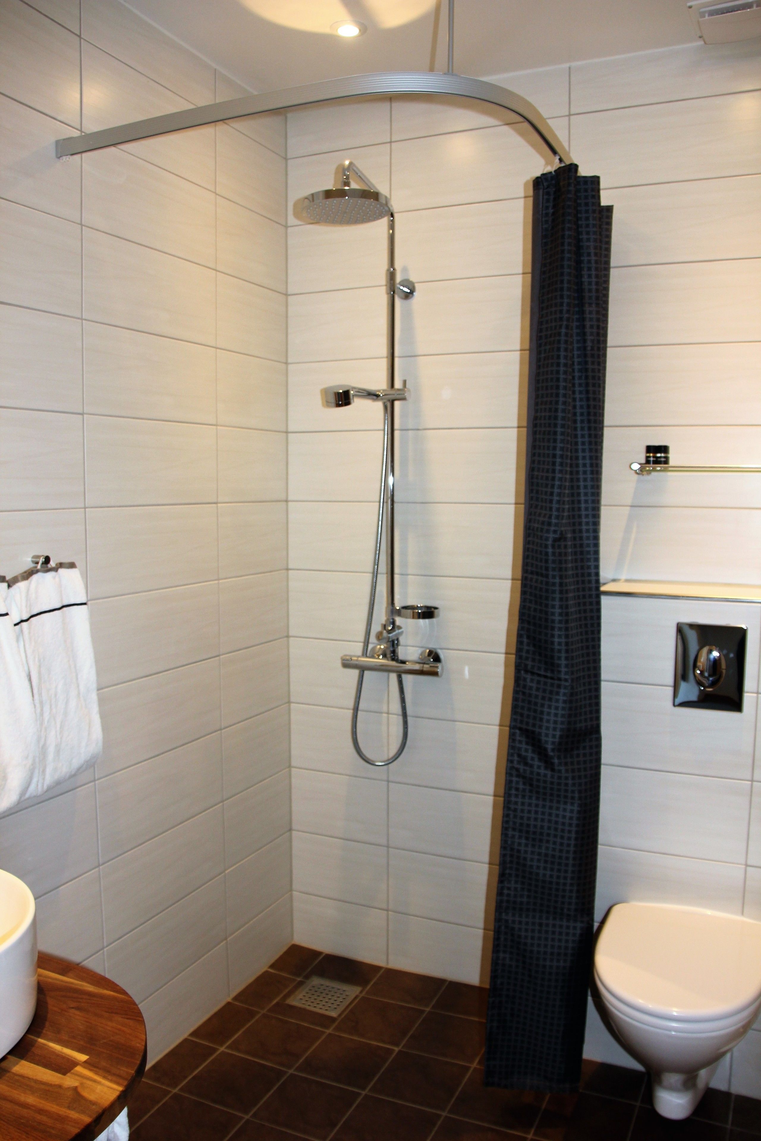 A modern bathroom with a shower, toilet, and sink.