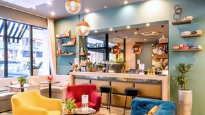 A modern hotel lobby with a bar area, seating arrangements, and a large window offering a view of the street. - Roombach Hotel Budapest Center (Budapest)