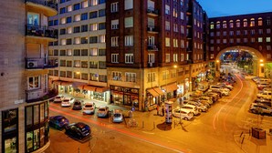 A multi-story hotel with balconies, a parking lot, and a street view. - Roombach Hotel Budapest Center (Budapest)