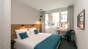 A hotel room with a large bed, a desk, and a window with curtains. - Roombach Hotel Budapest Center (Budapest)