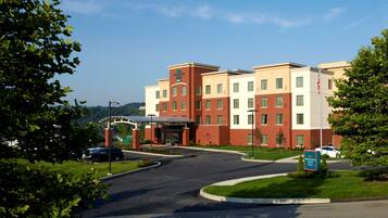 A hotel with a brick facade, multiple floors, and a covered entrance.