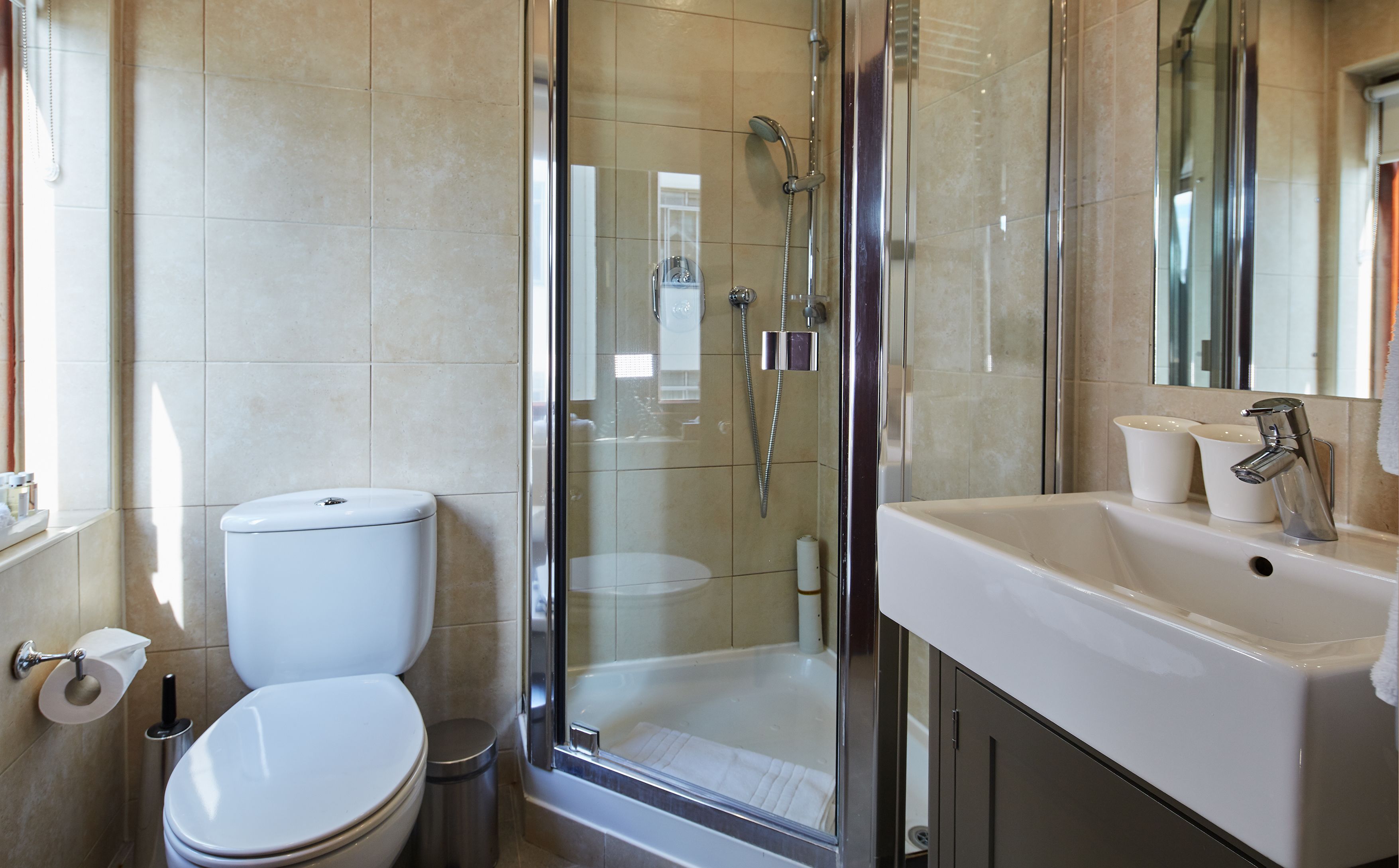 Une salle de bain moderne équipée de toilettes, d’une douche et d’un lavabo.