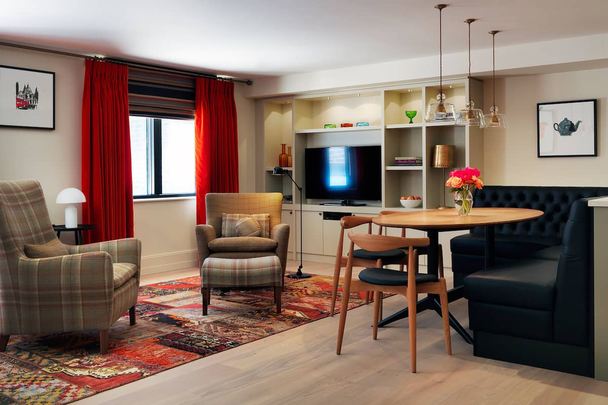 A modern living room with a television, a dining table, and a sofa.