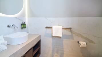 A bathroom with a white sink, a towel rack, and a toilet paper holder.