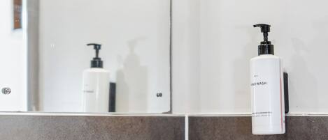 Une salle de bain avec un lavabo blanc, un robinet chromé et un miroir au-dessus.