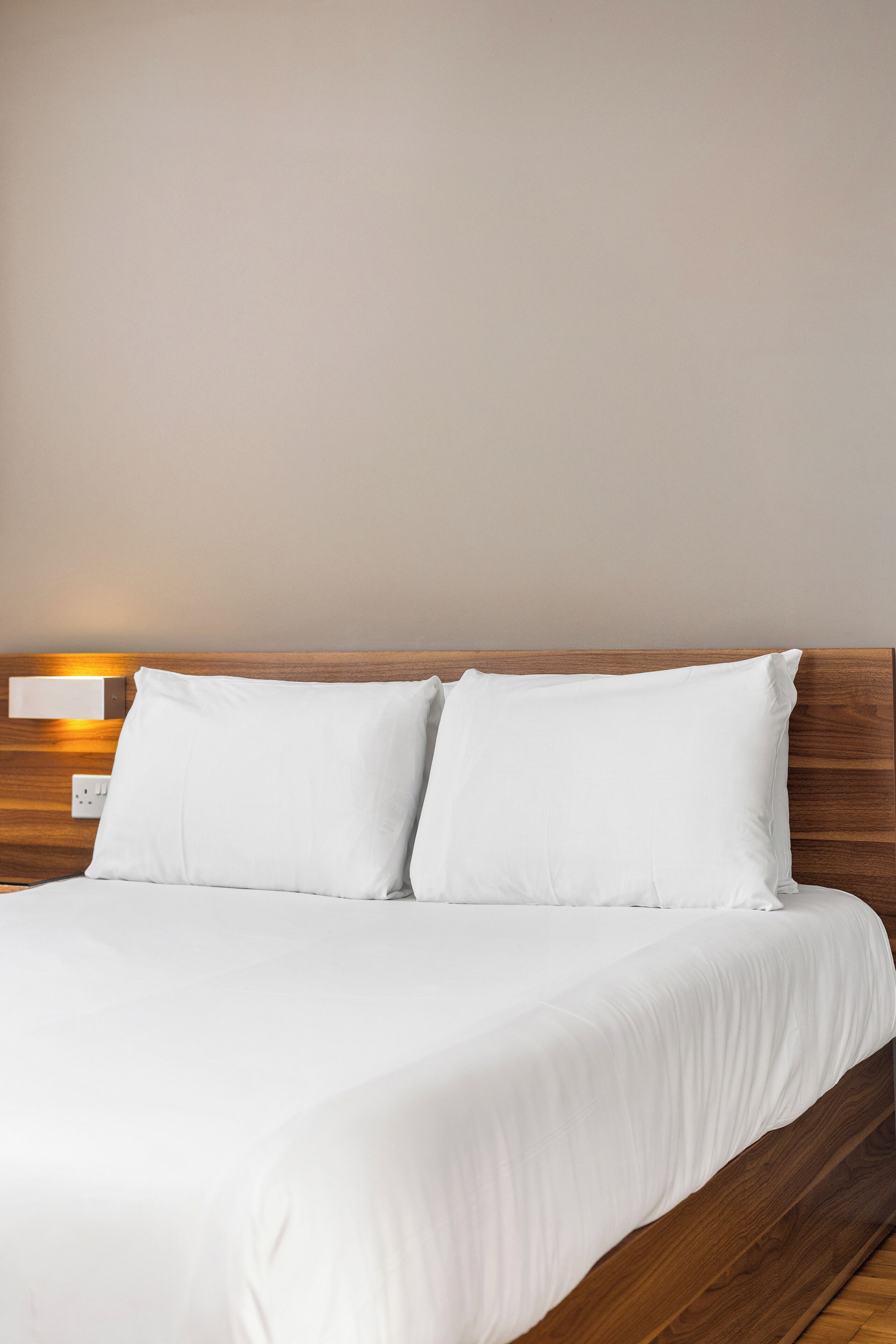 A bed with white bedding and a wooden headboard.