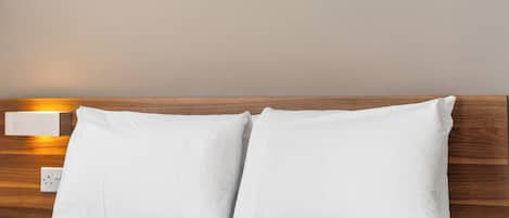 A bed with white bedding and a wooden headboard.