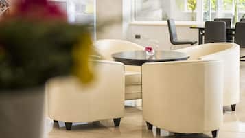 Un área de descanso moderna con una mesa redonda y dos sofás color crema.