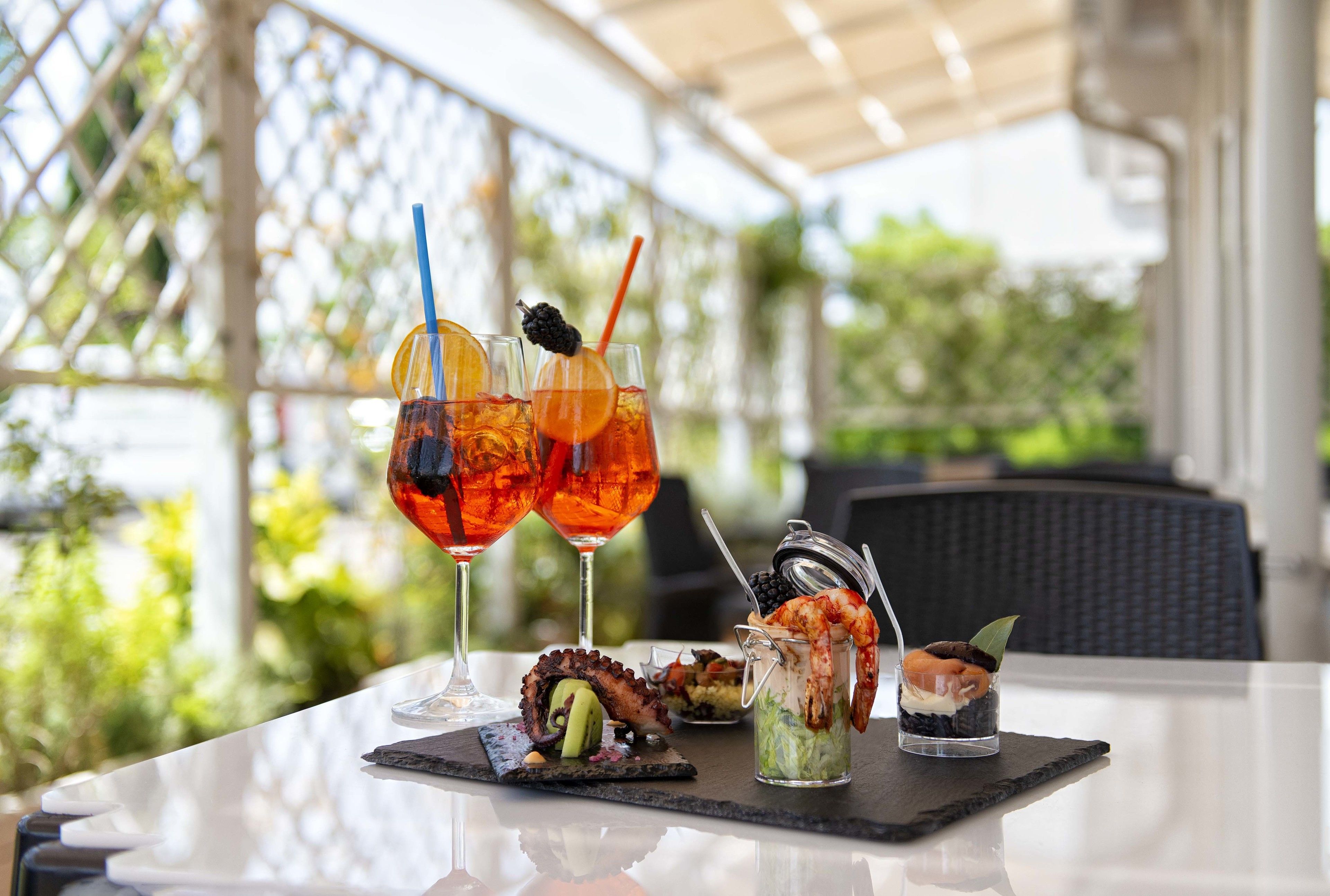 A table with drinks, seafood, and a dessert.