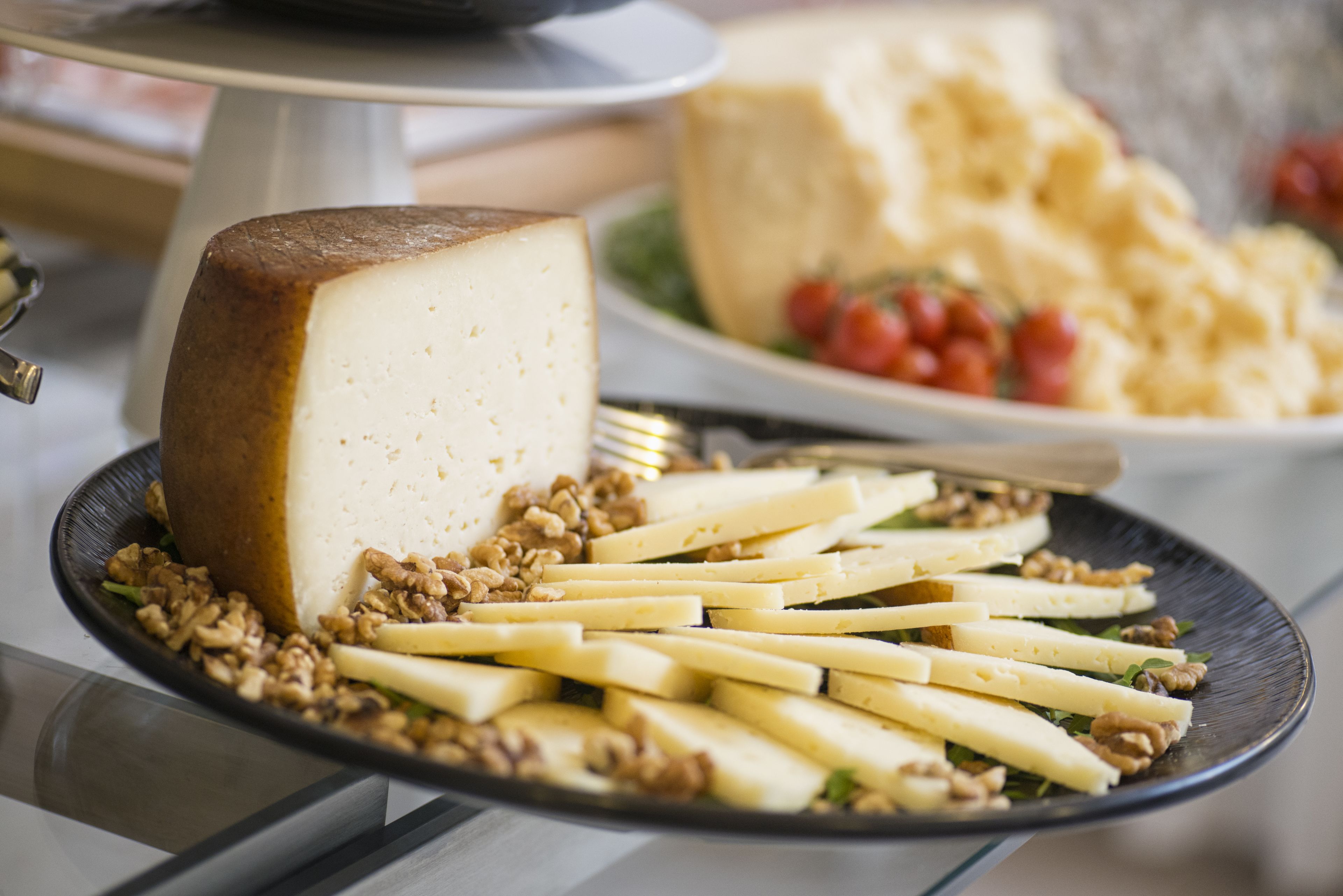 Un tagliere con diversi formaggi e noci su un piatto.