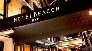 The HotelBeacon sign in NYC with illuminated letters, an American flag, and a marquee. - Hotel Beacon (New York)