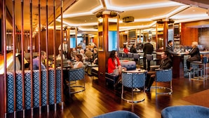 A modern lounge area with seating arrangements and a bar. - Hotel Beacon (New York)