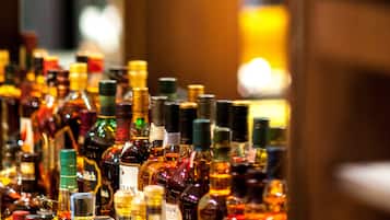 A bar with a sign reading "BEACONBAR" and a variety of liquor bottles on display.