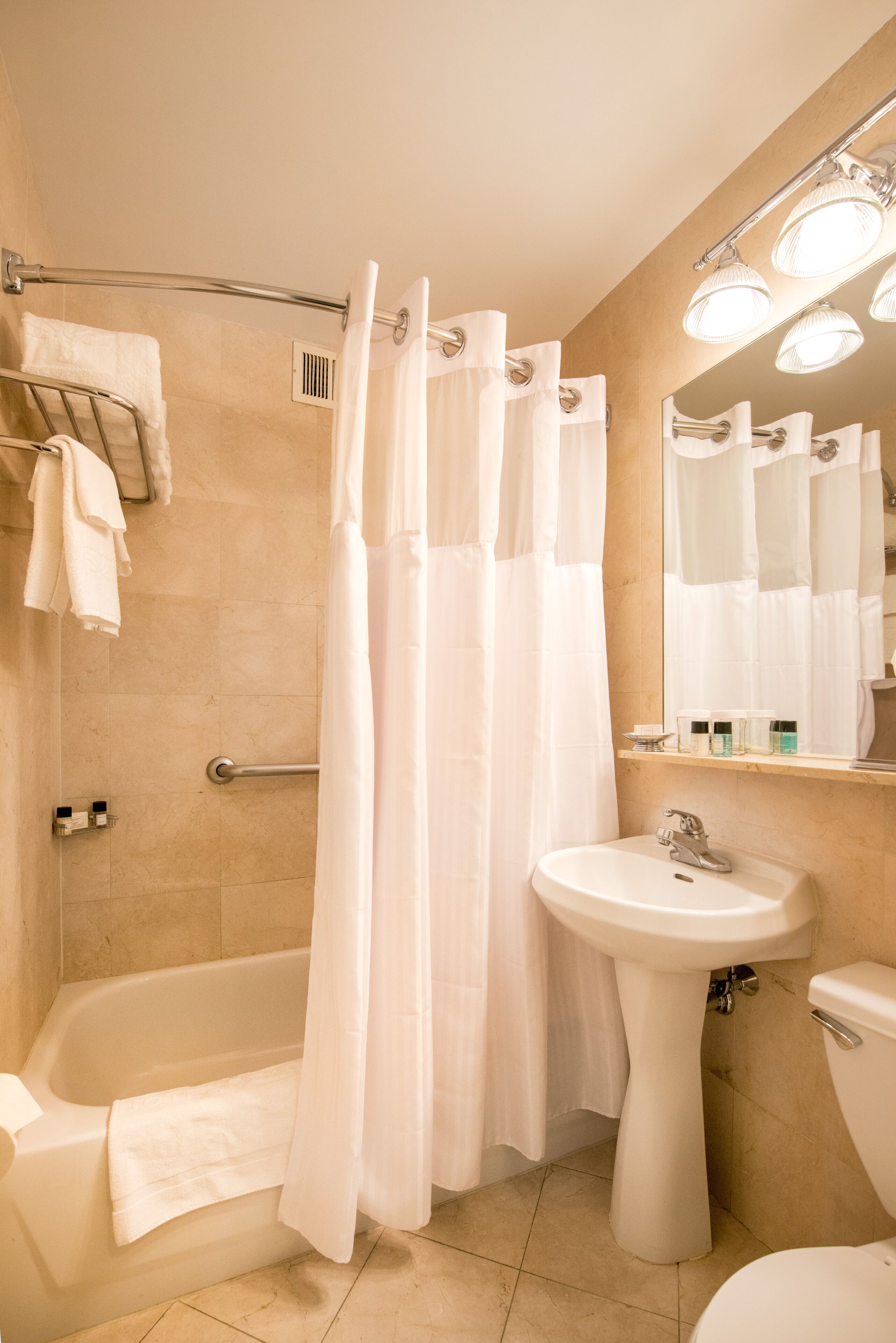 Un baño con bañera, lavamanos e inodoro.