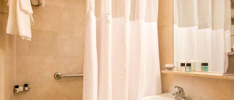 Un baño con bañera, lavamanos e inodoro.