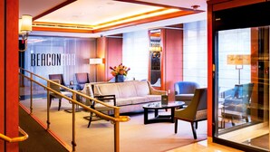 A hotel lobby with a sofa, chairs, a coffee table, and a staircase. - Hotel Beacon (New York)