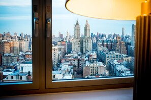 A cityscape through a window with a view of tall buildings and a lamp. - Hotel Beacon (New York)