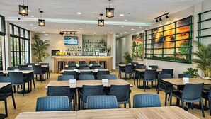 A restaurant with multiple tables and chairs, a bar area, and large windows. - Red Coco Inn de Boracay (Boracay Island)