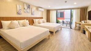 A hotel room with two beds, a desk, and a balcony with a view. - Red Coco Inn de Boracay (Boracay Island)