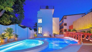 A modern hotel with a pool area, a red bridge, and a staircase leading to the entrance. - Red Coco Inn de Boracay (Boracay Island)