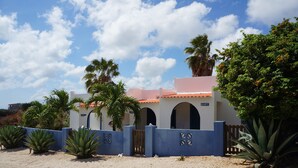 A building with a white facade, red-tiled roof, and arched windows. - Caribbean Chillout (Kralendijk)
