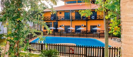 Una piscina al aire libre, sillones reclinables de piscina