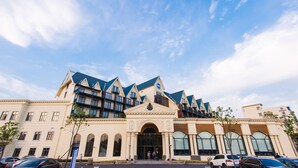 Un grand hôtel doté d’une entrée imposante, de nombreux balcons et d’une architecture moderne.