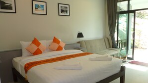 A hotel room with a bed, a sofa, and a glass table. There are pictures on the wall and a window with curtains. - Sun Moon Star Resort Koh Phangan (Ko Pha-ngan)