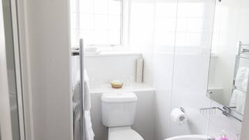 Ein modernes Badezimmer mit Toilette, Waschbecken und Fenster.