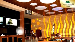 Un área VIP de karaoke con un mostrador de recepción de madera, asientos cómodos y una pared con diseños circulares.